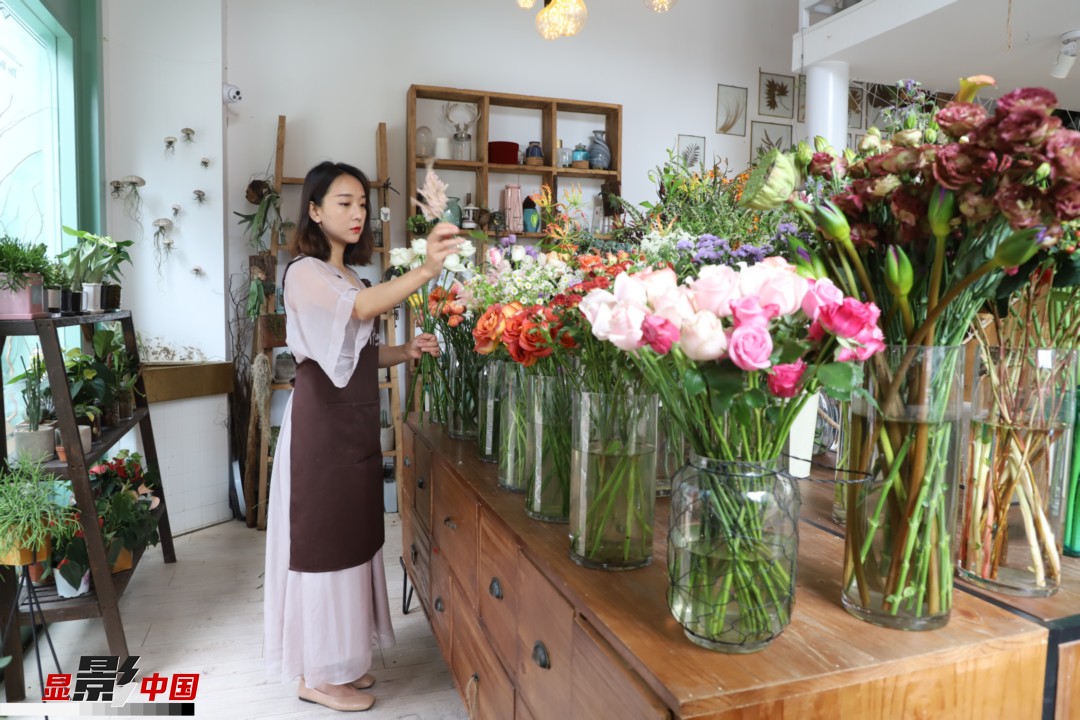 王黎媛是一名河南姑娘，在昆明念完大學(xué)后，就再也舍不下春城的藍(lán)天陽(yáng)光、青山碧水，更舍不下這里的四時(shí)繁花，于是就干脆留了下來，成了一名媒體人。2017年的時(shí)候又毅然辭去工作，創(chuàng)業(yè)開起了花店，成了都市里的一名“花房姑娘”。圖為王黎媛在自己的花店中整理鮮花。新華網(wǎng) 周亞平/攝 念新洪/文